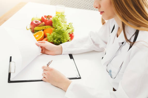 istock Nutritionist doctor writing diet plan on table 939085316