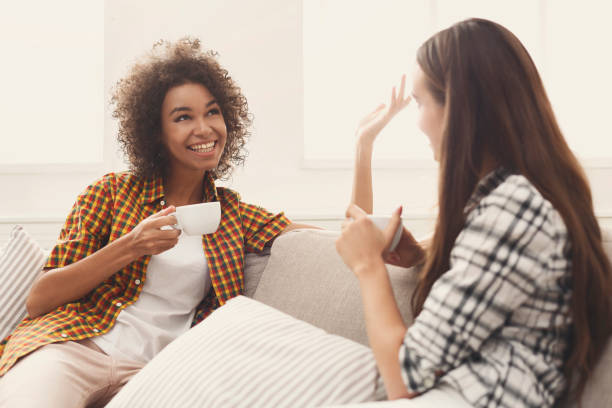 istock Two young female friends with coffee conversing 939085644