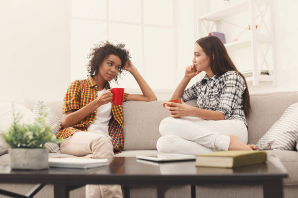 istock Two young female friends with coffee conversing 939086152