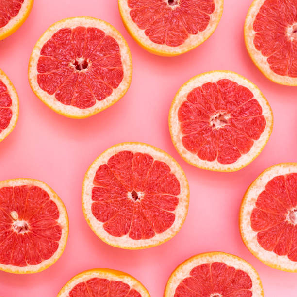 istock Background of grapefruits split in half on a pink background 939088986
