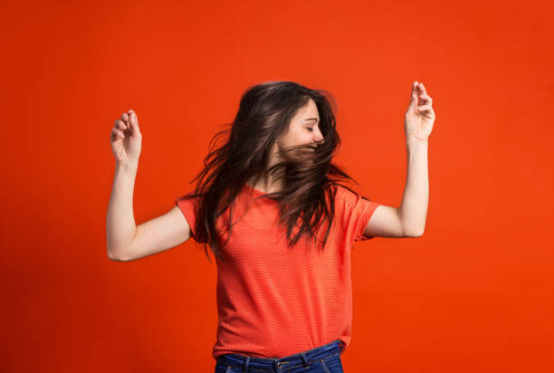 A young woman in studio on a red background.