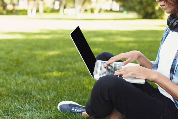 istock Unrecognizable black woman using laptop in park 939090610