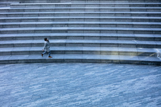 istock Businessman on cell phone running on city staircase 939098574