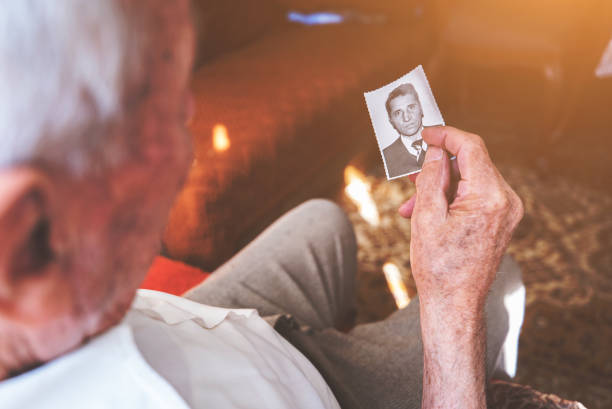 istock Old man holding a photograph 939104236