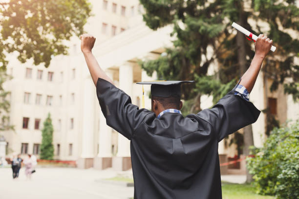 szczęśliwa młoda kobieta w dniu jej ukończenia. - mortar board child female people zdjęcia i obrazy z banku zdjęć