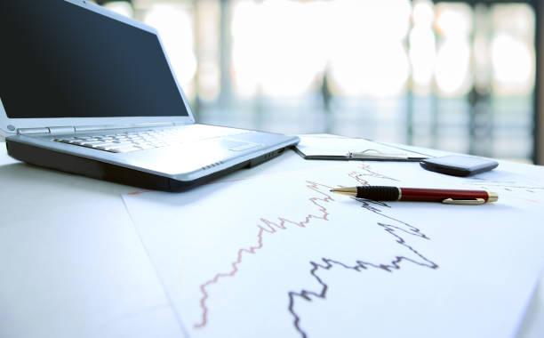 business background.a laptop computer and financial graph on th - finance stock market data diagram calculator imagens e fotografias de stock