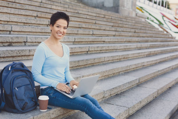 istock Smiling female freelancer working on a laptop outside 939117294