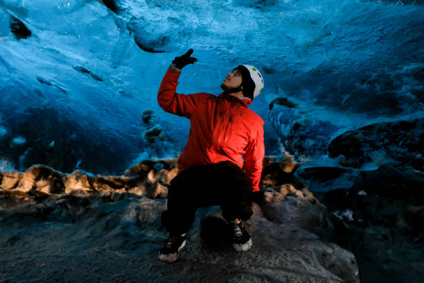 uomo in una grande grotta di ghiaccio in islanda - skaftafell glacier foto e immagini stock