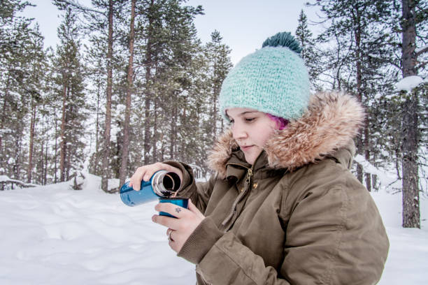 istock Young Woman Drinking Hot Tea in Winter Forest 939117908