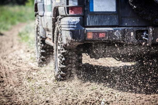 off-road racing voiture passer comme un éclair le long d’une route de campagne. - sports utility vehicle 4x4 car mud photos et images de collection