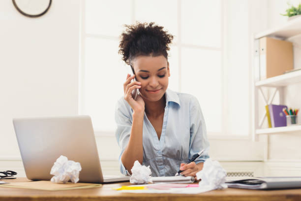 istock Smiling woman consulting by phone at office 939128474