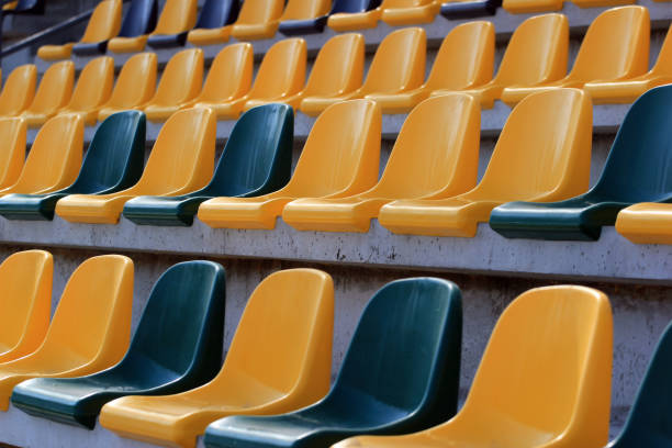 istock Rows of plastic black and yellow seats at a stadium 939129602