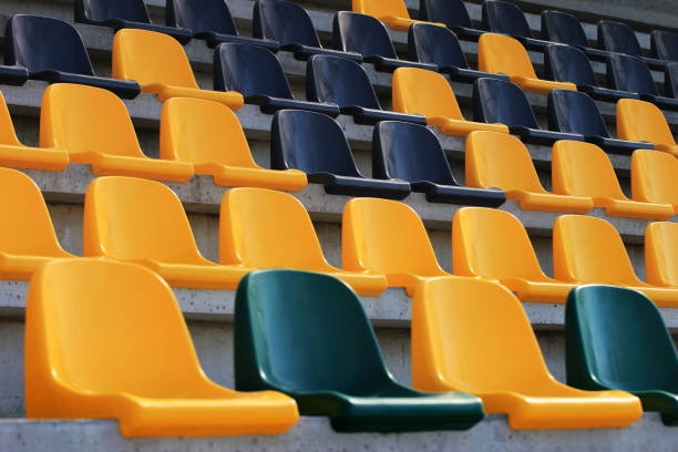 istock Rows of plastic black and yellow seats at a stadium 939129638