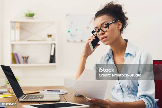 Serious Woman Consulting By Phone At Office Stock Photo - Download Image Now - Using Phone, Serious, Women