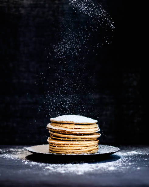 homemade apple pancakes sprinkled with powdered  sugar on wooden table