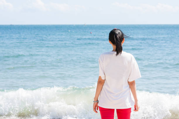 istock Girl facing the sea 939131300