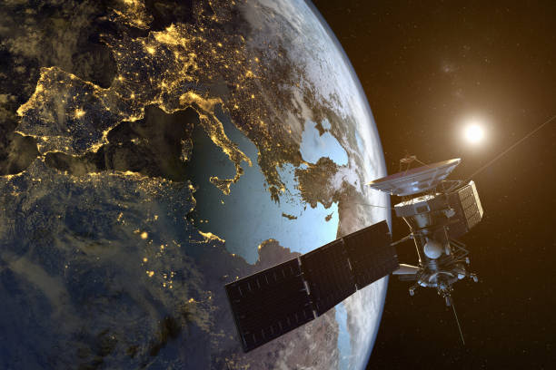 un satellite in orbita intorno alla terra con città illuminate di notte - satellite foto e immagini stock