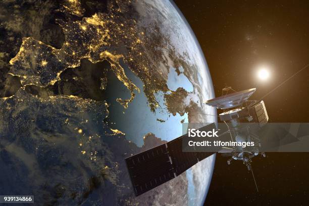 A Satellite Orbiting The Earth With Illuminated Cities At Night Stock Photo - Download Image Now