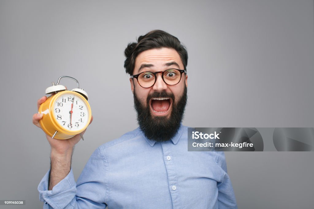 Hombre asustado con reloj despertador - Foto de stock de Fecha tope libre de derechos