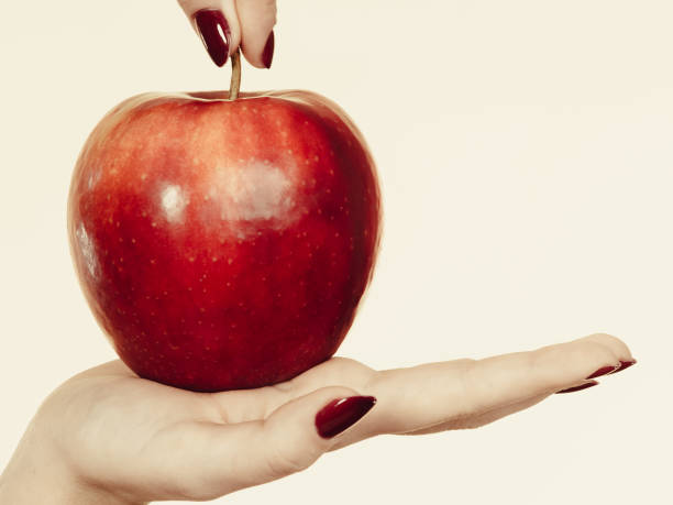 istock Woman hand holding delicious red apple 939146076