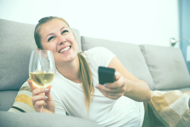 istock Girl is resting with wine and watching TV 939148910