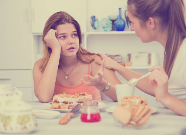 istock Female talking with young sad friend at home 939148978