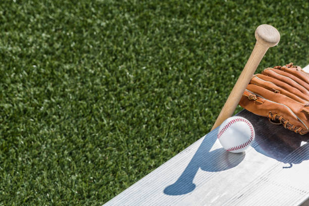istock Looking down on a new baseball, a baseball glove and wooden bat on bench 939149590