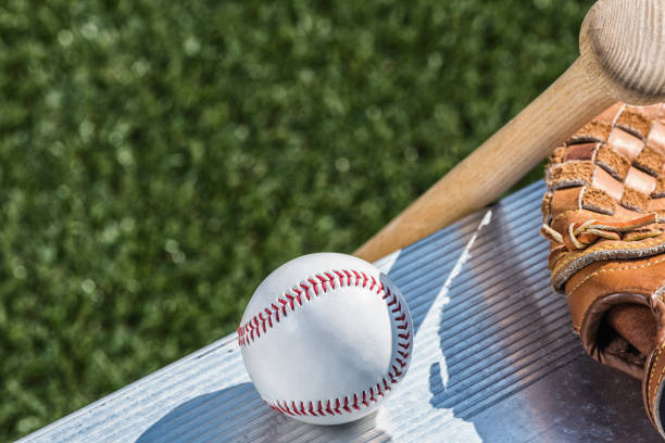istock Looking down on a new baseball, a baseball glove and wooden bat on bench 939149698