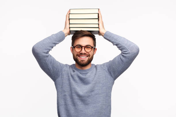 studente diligente sorridente con pila di libri - student effort book carrying foto e immagini stock