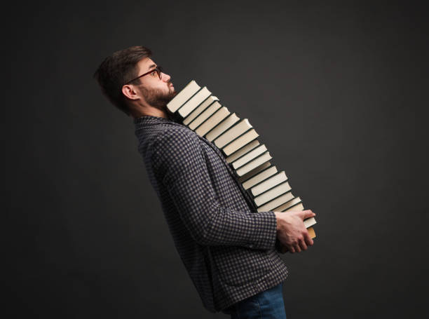 istock Man carrying plenty of books 939150034
