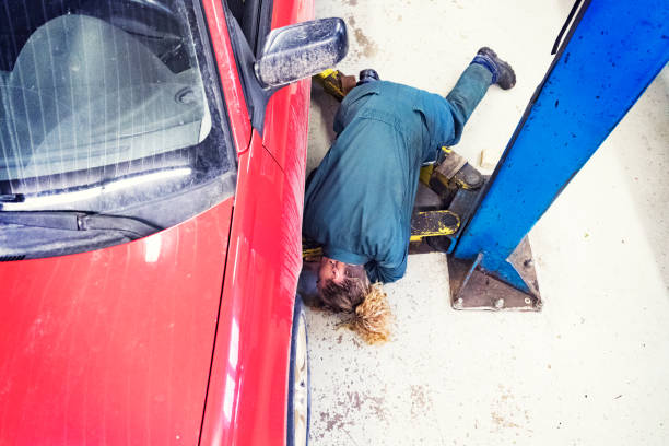 Over the top view of a female mechanic looking under a car Looking under a car to see what is wrong with the car she is tasked to repair. car mechanic top view stock pictures, royalty-free photos & images