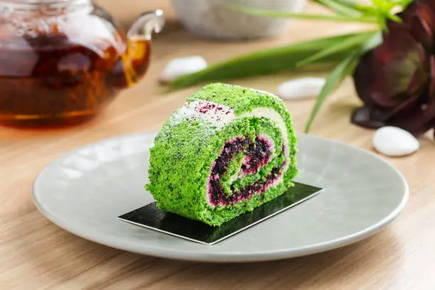 Photo of Serving portion of green spinach roll cake with cream cheese and currant filling