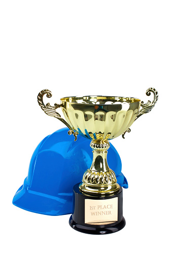 Hardhat and a gold trophy isolated over white background