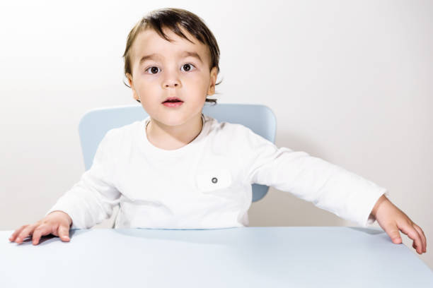 istock Cute little boy sitting at the table 939154678