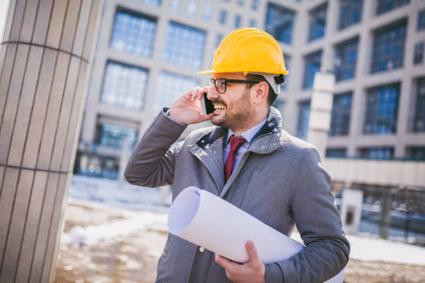 istock Architect in protective helmet speaking by phone 939155588