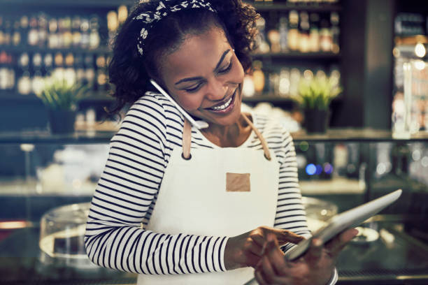 istock Smiling African cafe owner taking reservations over the phone 939159564