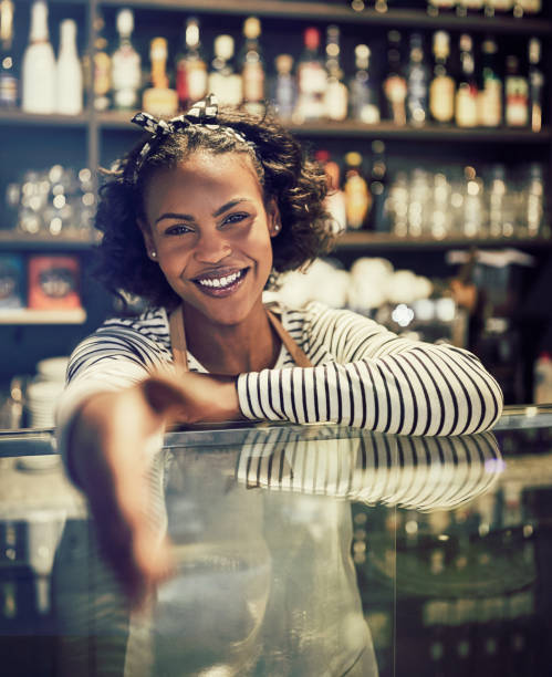 istock Smiling African entrepreneur shaking hands from behind her cafe counter 939159908