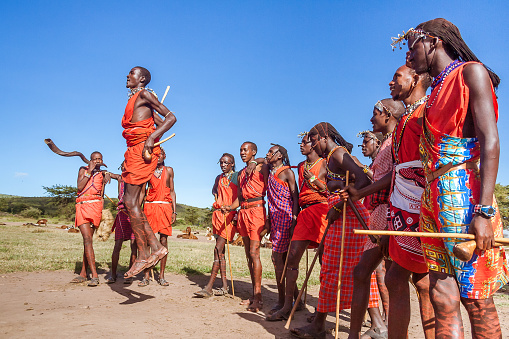 Masai Mara, Kenya, May 23, 2017: Masai warriors in traditional costume jumping during a ritual.