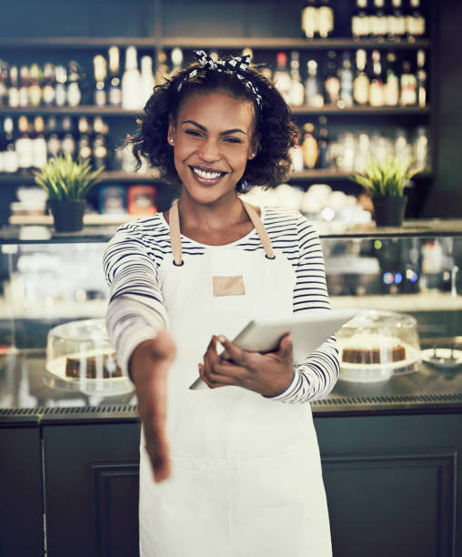 istock Smiling hostess offering a handshake in a cafe 939160258