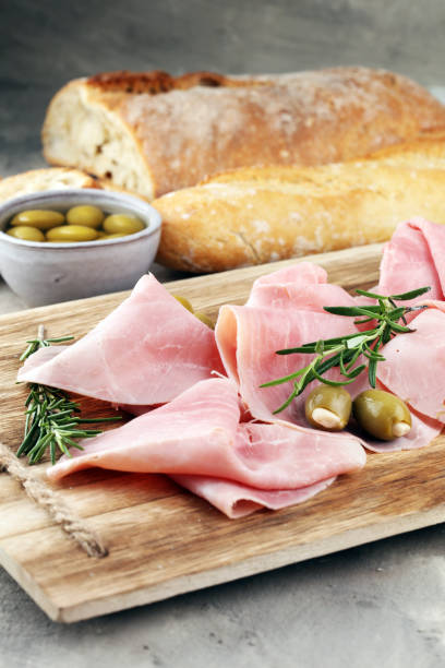 istock Sliced ham on wooden board. Fresh prosciutto. Pork ham sliced. 939160386