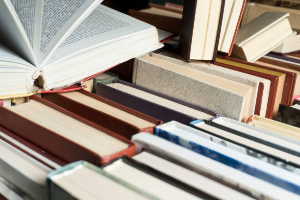 istock Book stacking open book hardback books on wooden table. 939163184
