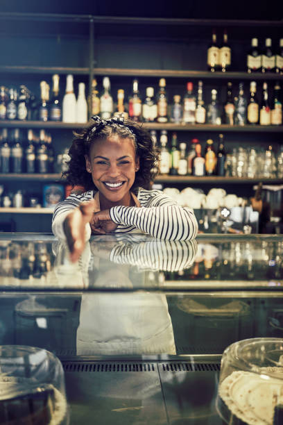 istock Young African entrepreneur shaking hands from behind her cafe counter 939163460