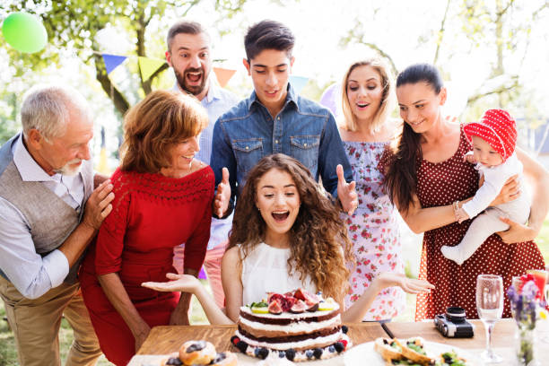 Family celebration or a garden party outside in the backyard. Family celebration outside in the backyard. Big garden party. Birthday party. A teenage girl with a birthday cake. birthday wishes for daughter stock pictures, royalty-free photos & images