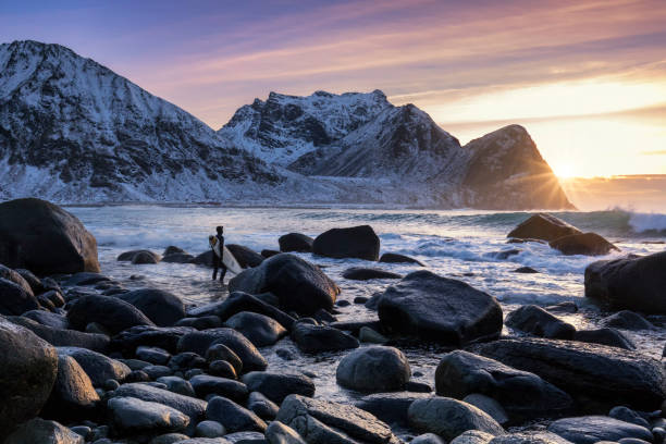 persona que practica surf soy zum strand von unstad sonnenuntergang - lofoten and vesteral islands beach nature norway fotografías e imágenes de stock