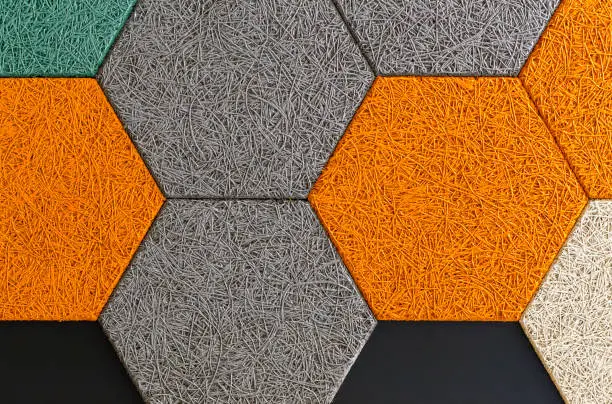 Comb shape of soundproofing panels in orange, gray and black color.