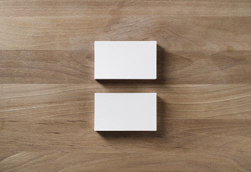 Two blank horizontal business cards on wooden table background. Flat lay.