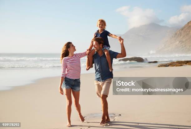 Parents Carrying Son On Shoulders On Beach Vacation Stock Photo - Download Image Now