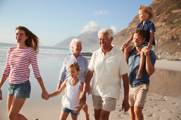 istock Multi Generation Family On Vacation Walking Along Beach Together 939178886