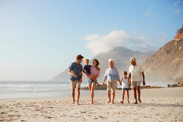 istock Multi Generation Family On Vacation Walking Along Beach Together 939180794