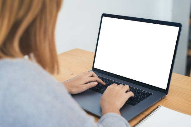 istock Young Asian woman working using and typing on laptop with mock up blank white screen while at home in office work space. Businesswoman working from home via portable computer. Enjoying time at home. 939181056